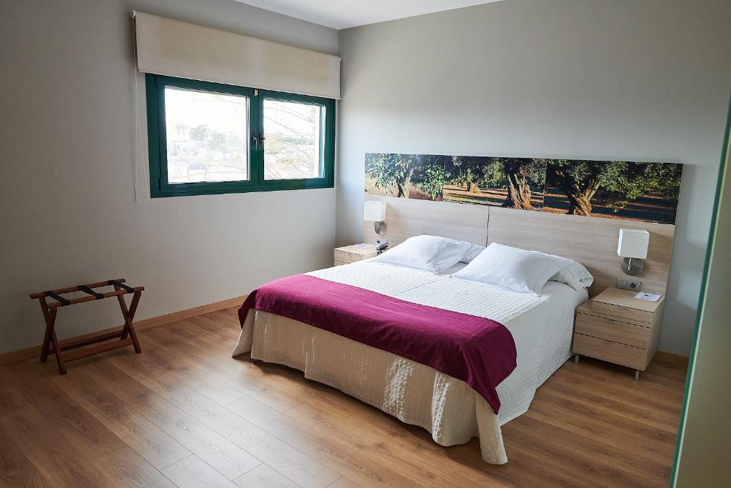 sypialnia z dużym łóżkiem i oknem w obiekcie Hotel L'Algadir del Delta w mieście El Poblenou del Delta