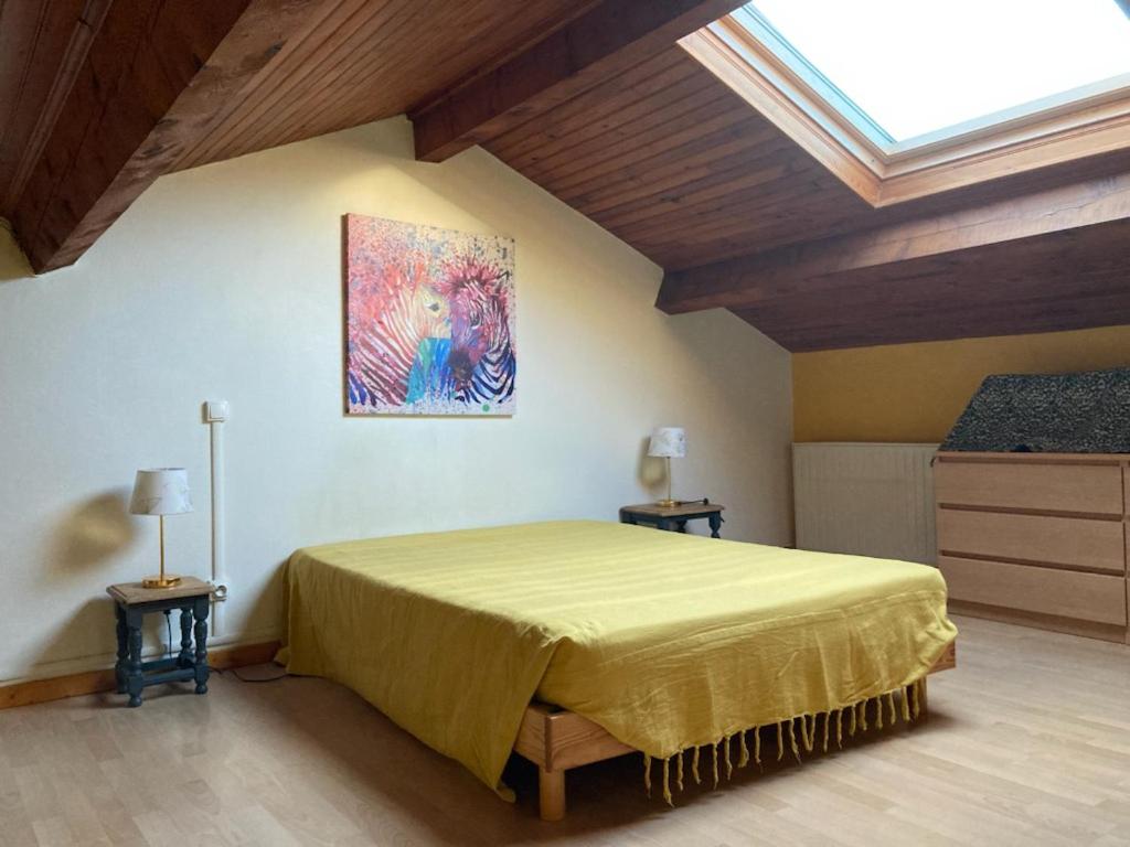 La Bastide-Pradines的住宿－Gîte Miss Cardabelle，卧室配有一张床,墙上挂有绘画作品