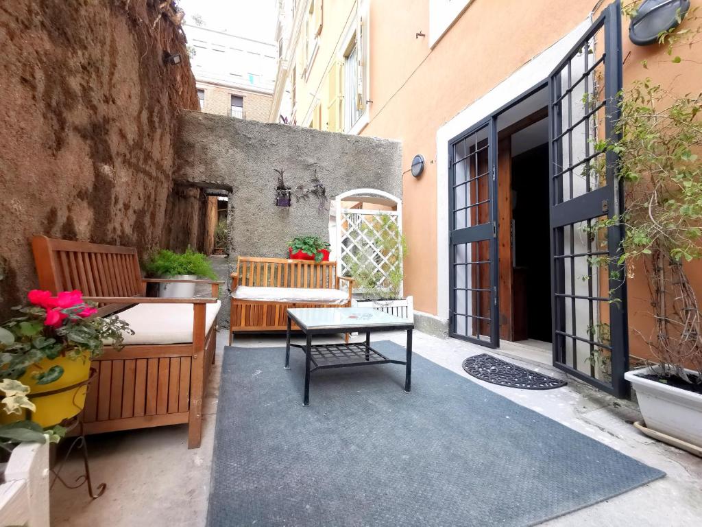 eine Außenterrasse mit einem Tisch und Stühlen in der Unterkunft Colosseo Home - 29061 in Rom