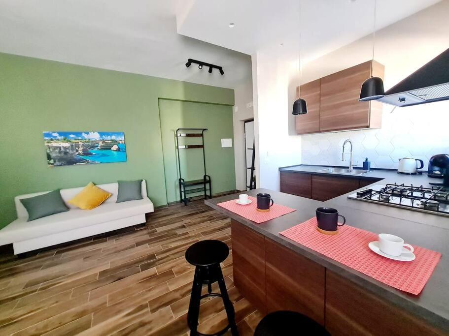 a kitchen and a living room with a couch at Hiera' in Lecce