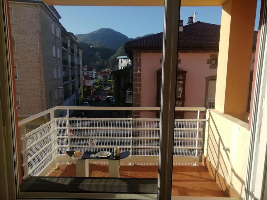 een balkon met een tafel en uitzicht op de stad bij TESOROS DE CANTABRIA apart.Luna G101687 in Ampuero