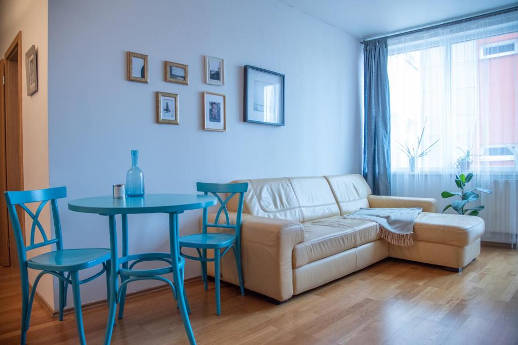 ein Wohnzimmer mit einem Sofa, einem Tisch und Stühlen in der Unterkunft Apartment Tereza in Prag