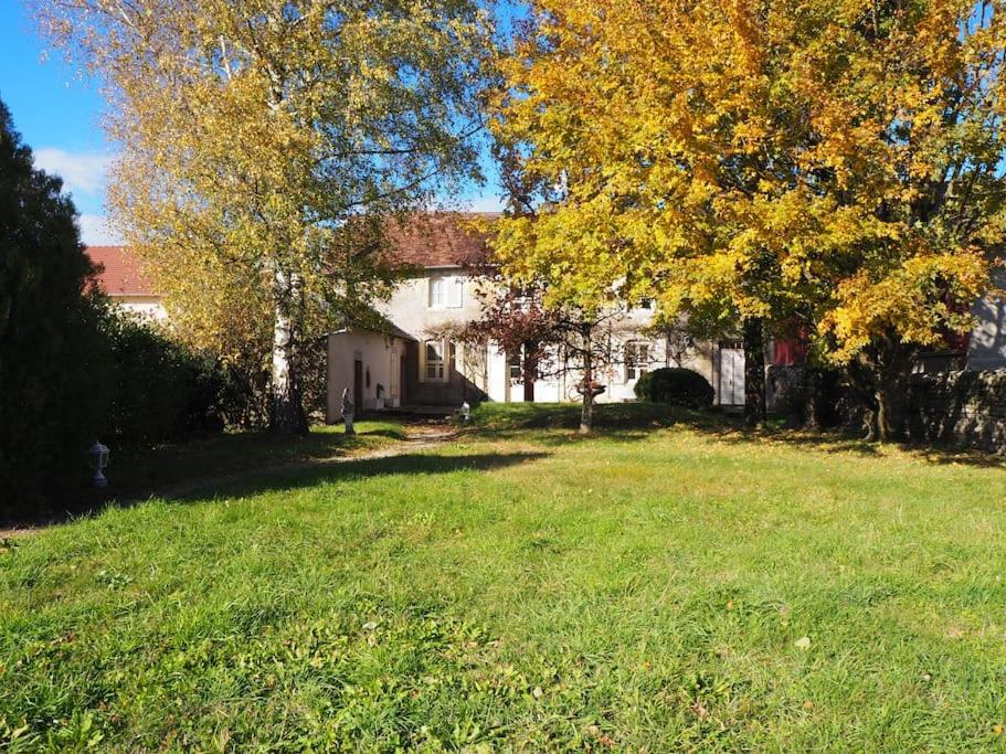 une maison blanche avec un arbre dans la cour dans l'établissement La Barretaine , une maison de caractère, à Barretaine