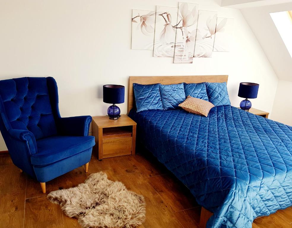 a bedroom with a blue bed and a blue chair at Flowers in the attic in Żywiec