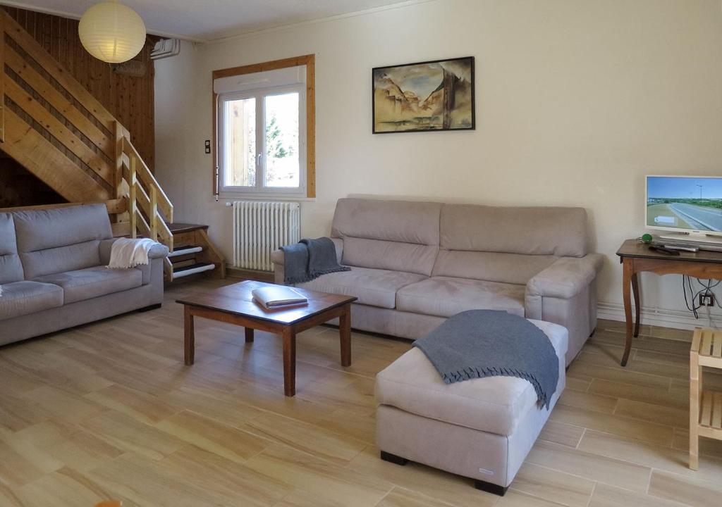 Sala de estar con 2 sofás y mesa de centro en Gîte SOLDANELLE - 15 personnes - "Les Gites du Chalet" à Autrans en Autrans