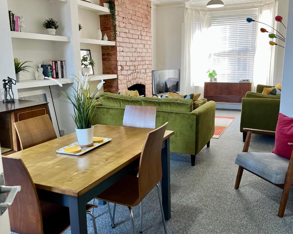 uma sala de estar com uma mesa e um sofá em Contemporary 2 Bedroom Victorian Town House em Kimberley