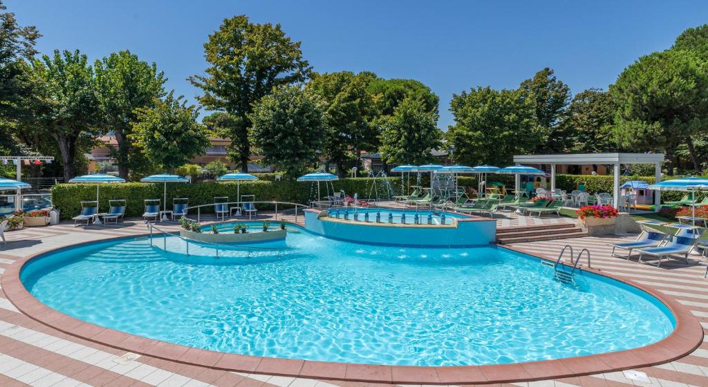 una piscina en un complejo con sillas y sombrillas en Hotel Smeraldo, en Cesenatico