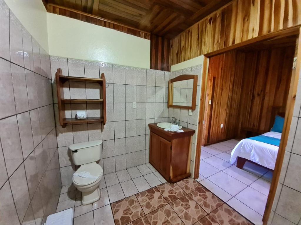 a bathroom with a toilet and a sink and a bed at Belcruz family lodge in Monteverde Costa Rica