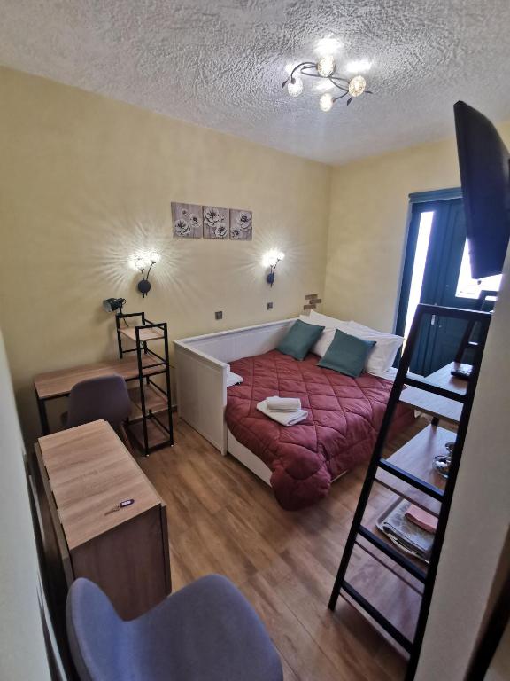 a small living room with a bed and a table at Serafi Cozy Rooms in Archangelos