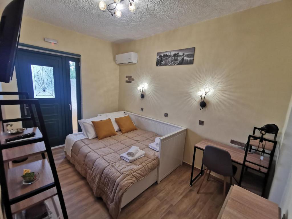 Habitación pequeña con cama y escritorio. en Serafi Cozy Rooms en Archangelos