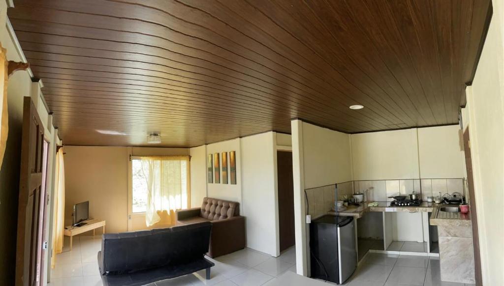 a kitchen with a wooden ceiling and a living room at Casa Esperanza in Río Cuarto