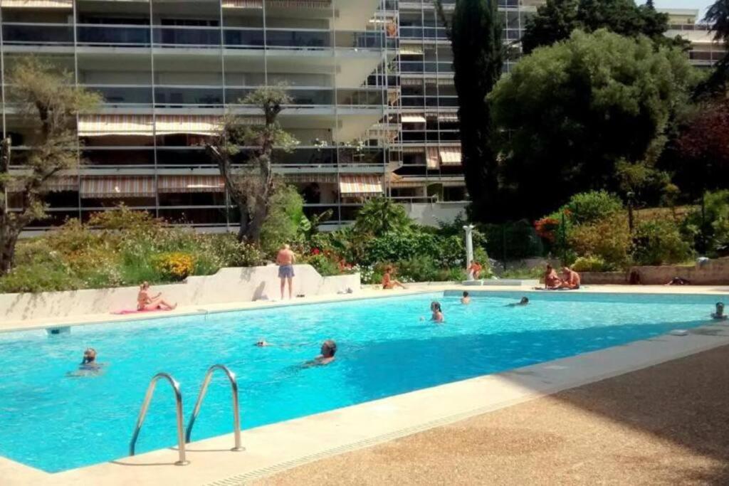 un groupe de personnes nageant dans une piscine dans l'établissement Superbe studio avec piscine ext, à Antibes