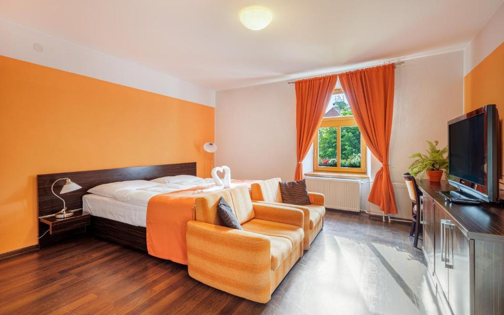 a hotel room with a bed and a couch at Apartmány Sladký sen in Kežmarok