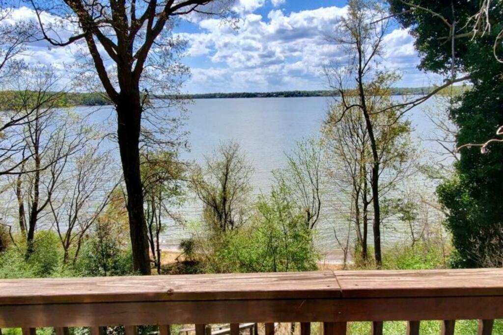 a view of a lake from a wooden bench at 2 BR Newly Renovated Waterfront Home; 10 min from MGM & the Gaylord in Fort Washington