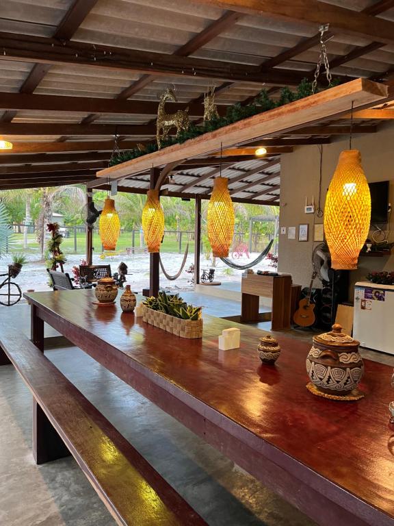 Pousada Paraíso do Calango Azul في بريزدنته فيغويردو: طاولة خشبية كبيرة في غرفة مع أضواء