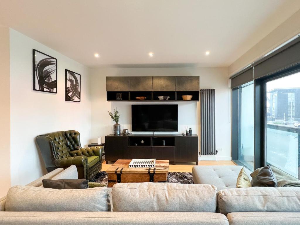 - un salon avec un canapé et une télévision dans l'établissement Lovely 2 Bed Duplex Apartment with Hydro Views, à Glasgow