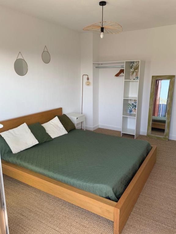 una camera da letto con un letto con un piumone verde di L'appart Fréjus plage a Fréjus