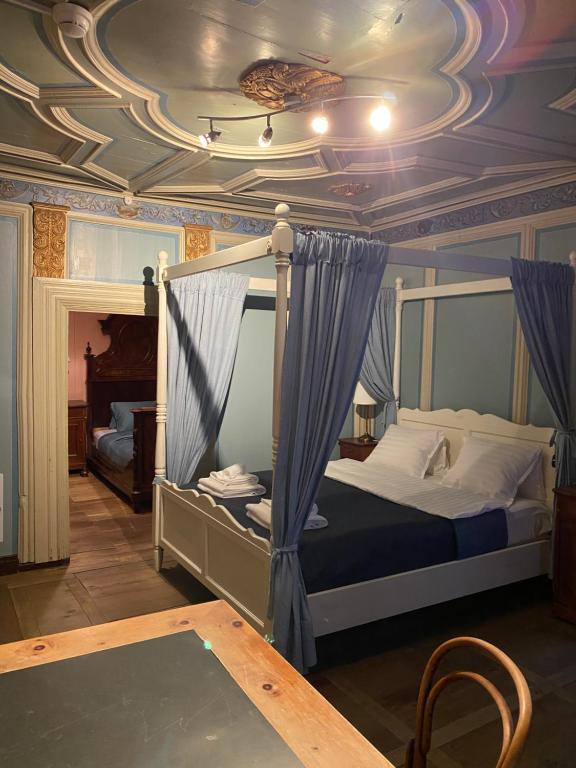 a bedroom with a canopy bed with a coffered ceiling at Hotel Corona in Vicosoprano