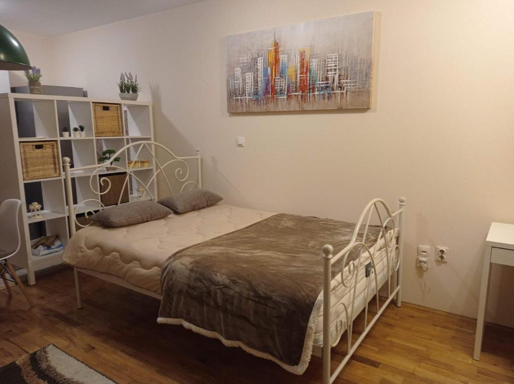 Zvezdara的住宿－NMD Apartments，卧室配有一张床,墙上挂有绘画作品