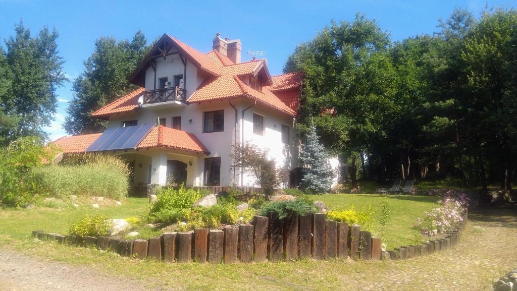 a large white house with a red roof at Leśna Polana in Stare Jabłonki