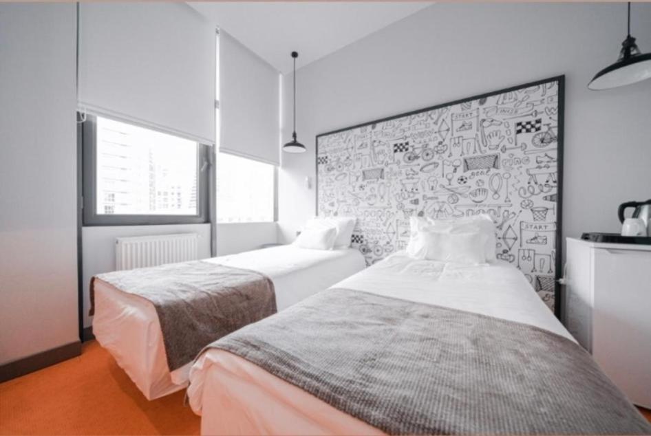 1 dormitorio con 2 camas y pared de ladrillo en Soul Entertainment Group, en Esenyurt