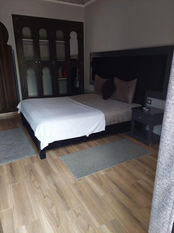 sypialnia z dużym łóżkiem i drewnianą podłogą w obiekcie Mymarrakechvillas w Marakeszu