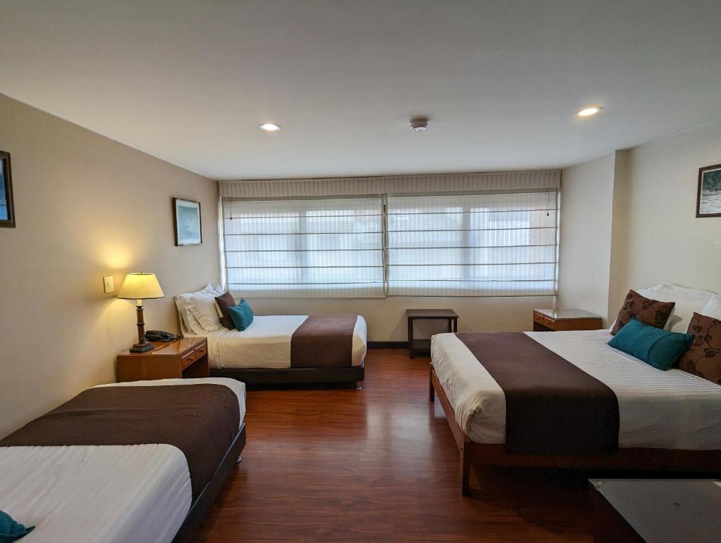 Cette chambre comprend 2 lits et une fenêtre. dans l'établissement Hotel La Sabana, à Bogotá