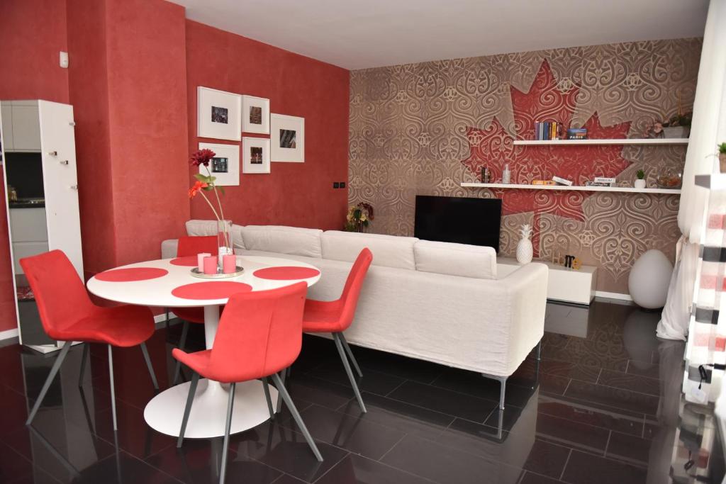 a living room with a white couch and red chairs at Design & Comfort a Romano di L. in Romano di Lombardia