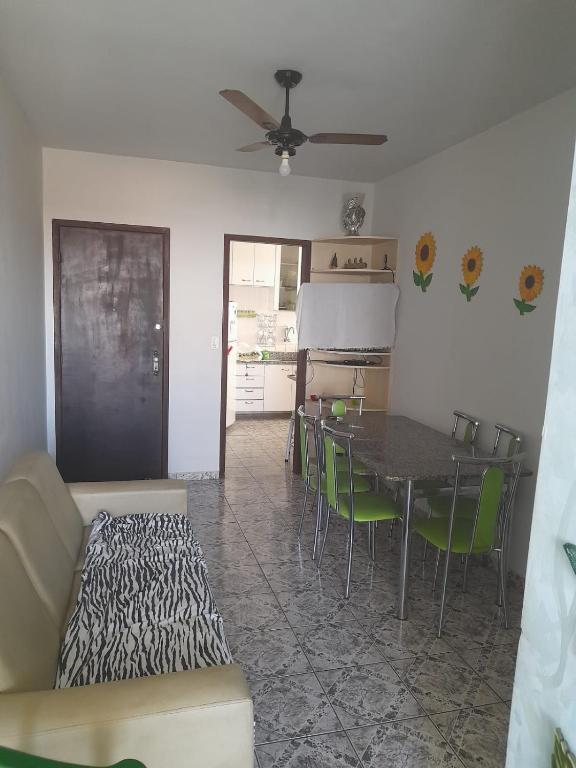 Ap 300m praia do morro في غواراباري: غرفة معيشة مع طاولة وكراسي خضراء