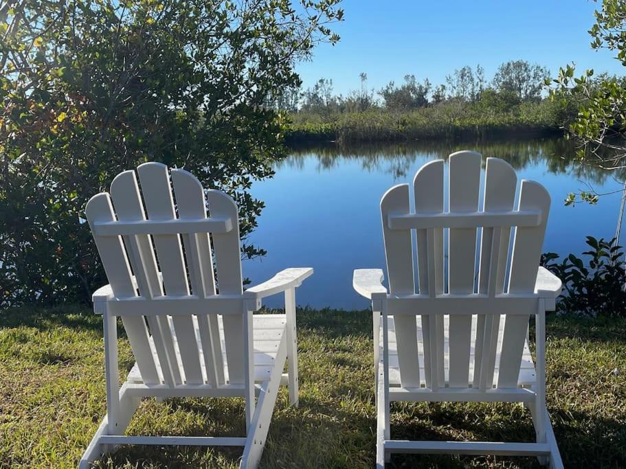 two white chairs sitting in front of a lake at Waterfront Condo #7 in Punta Gorda