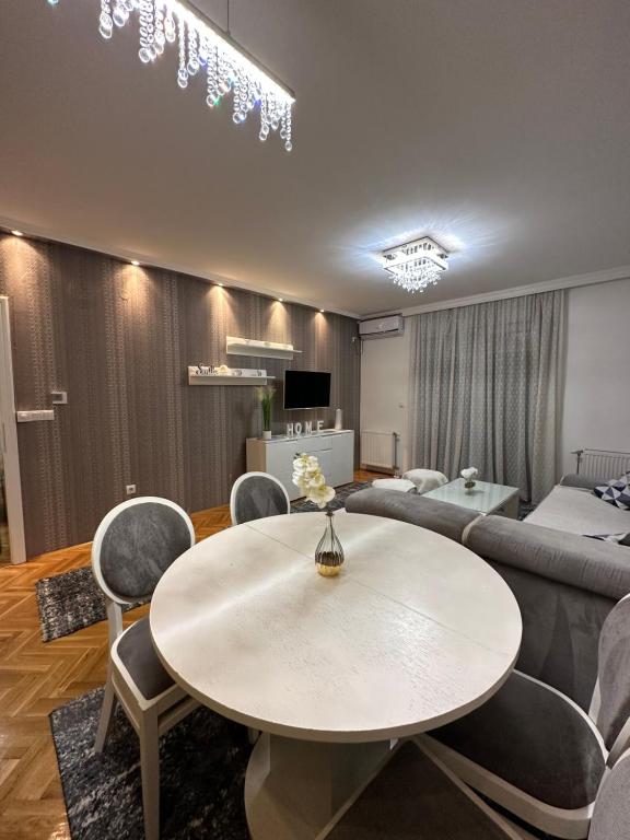 a living room with a table and chairs and a couch at Central Luxury Suites in Bijeljina