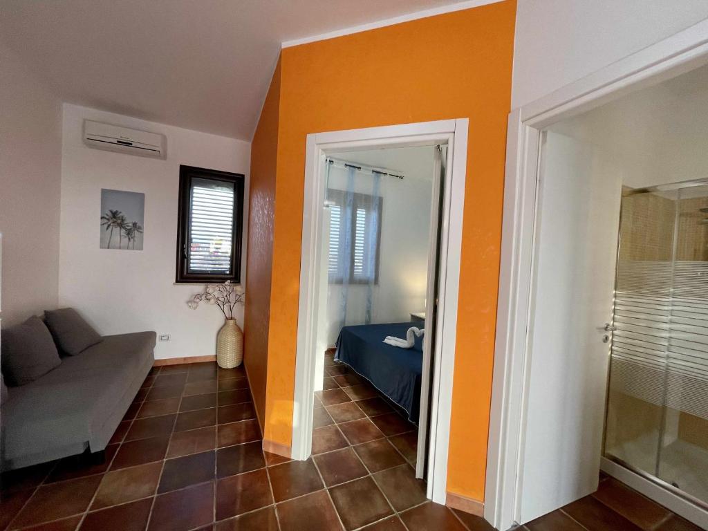 a living room with orange walls and a couch at Dammusi cala croce in Lampedusa