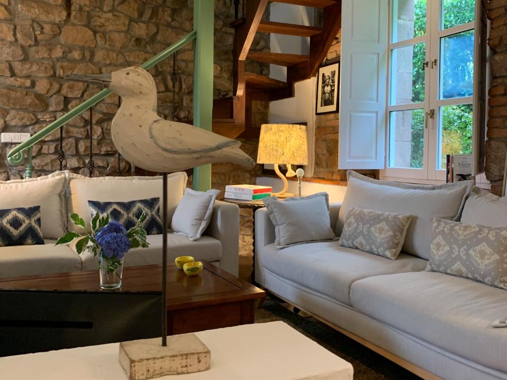 ein Wohnzimmer mit einem Sofa und einem Vogel auf einem Tisch in der Unterkunft El molino de La Infinita: Un coqueto molino con río propio in Carmona