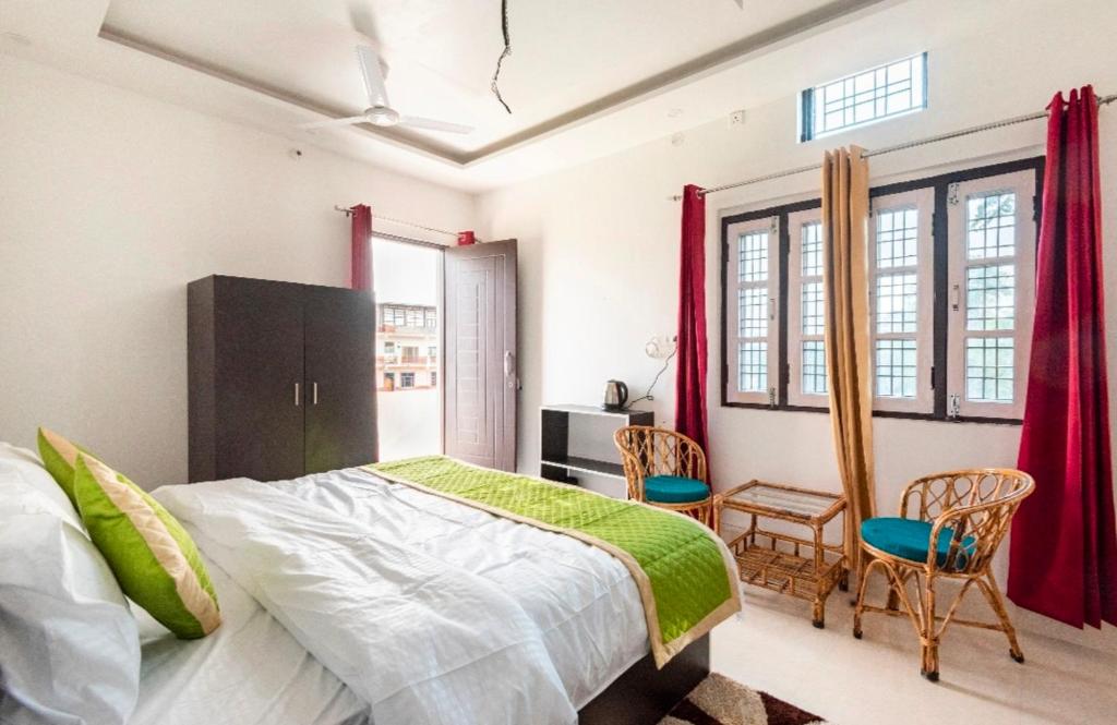 1 dormitorio con 1 cama y 2 sillas en Janki homestay, en Rāiwāla