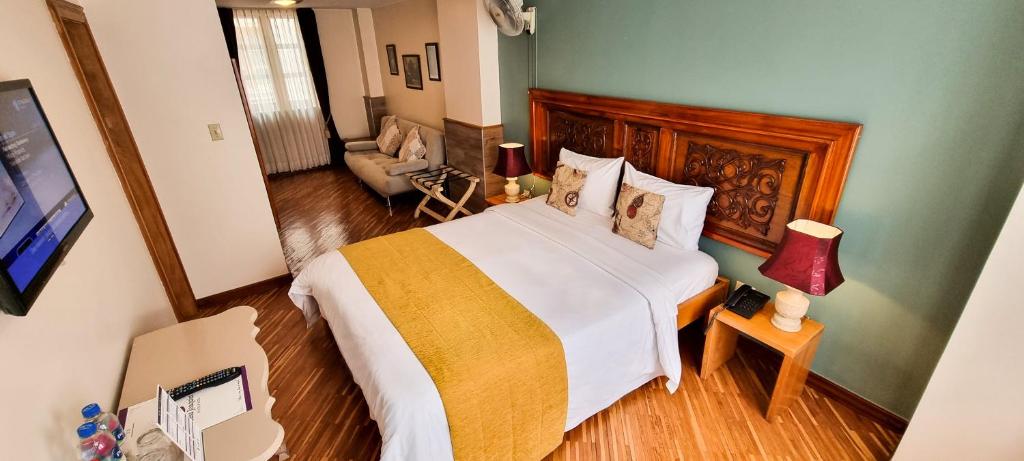 ein Schlafzimmer mit einem großen Bett und ein Wohnzimmer in der Unterkunft Casa Joaquin Boutique Hotel in Quito