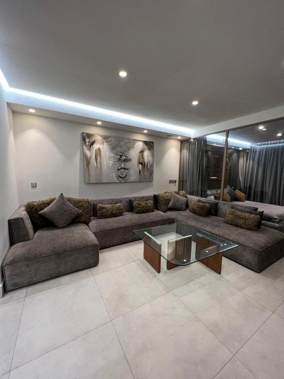 uma sala de estar com um sofá e uma mesa de vidro em Luxury apartment in Casablanca em Casablanca