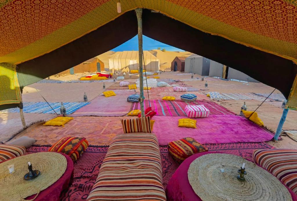 a tent with tables and chairs in the desert at Bivouac Luna in Mhamid