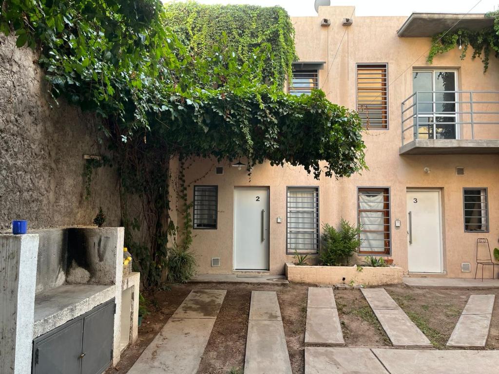 un edificio con dos puertas blancas y un árbol en Tierras del Malbec 1 en Luján de Cuyo