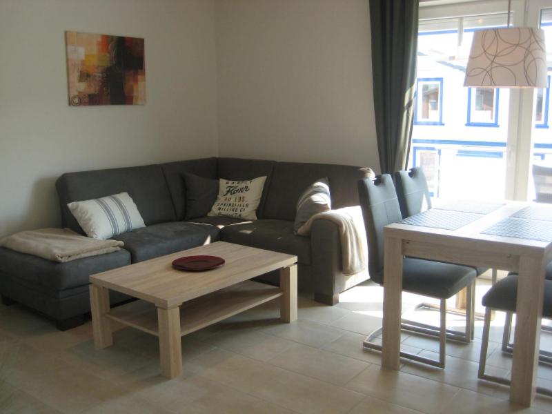 ein Wohnzimmer mit einem Sofa und einem Tisch in der Unterkunft Appartements Buesum DS10 in Büsum