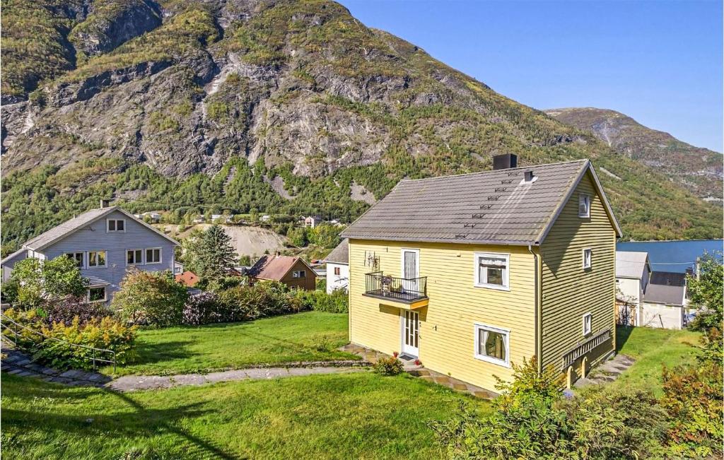 a yellow house in front of a mountain at Cozy Apartment In rdalstangen With Wifi in Årdalstangen