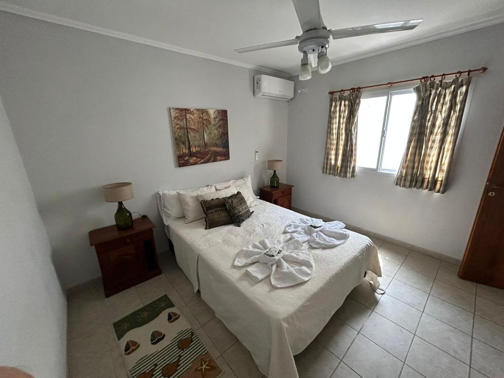 1 dormitorio con cama blanca con arco en Apartamentos en Federacion Zona Centro en Federación
