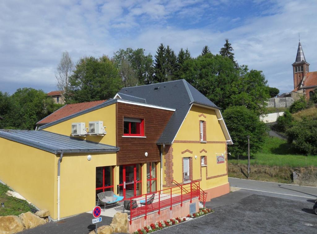 uma casa amarela com um telhado preto em Hôtel L'Argonn' Auberge em Apremont