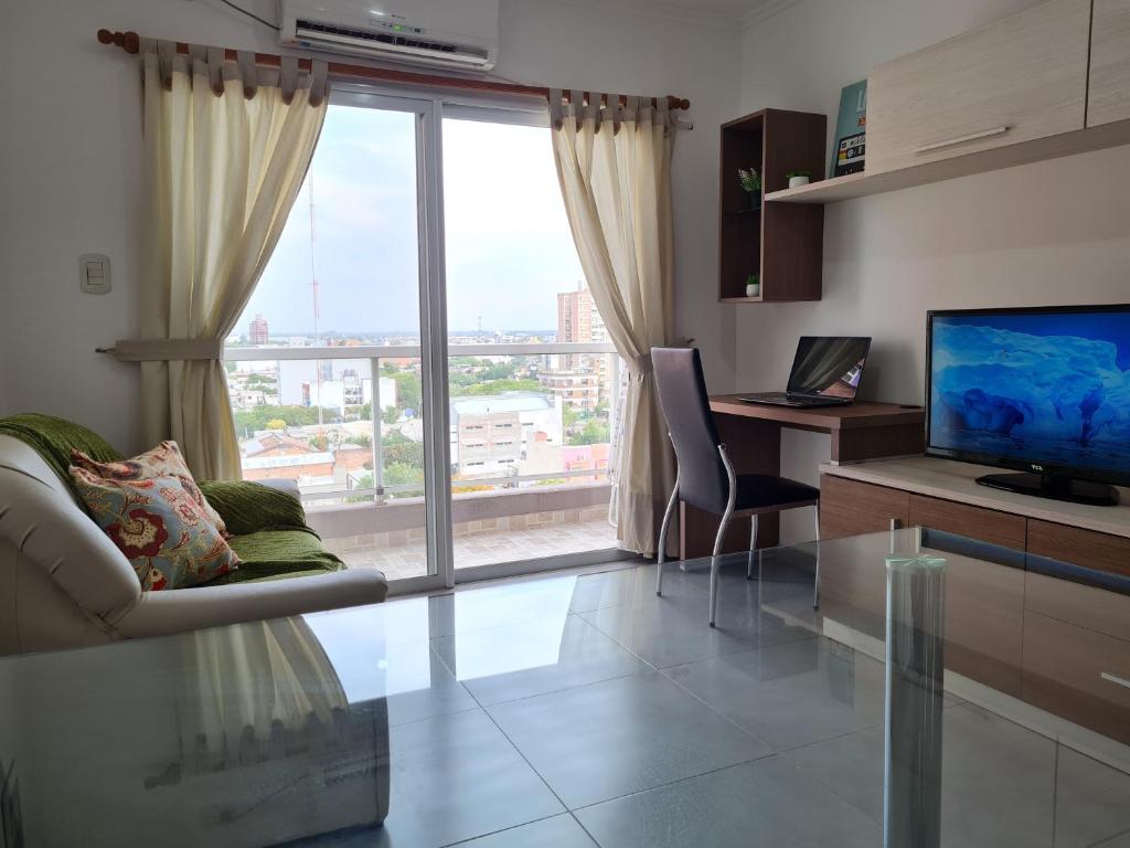 a living room with a large window and a television at Resistencia City Apartment in Resistencia