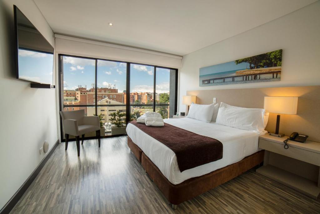 a hotel room with a bed and a large window at Hotel Espacio 94 in Bogotá