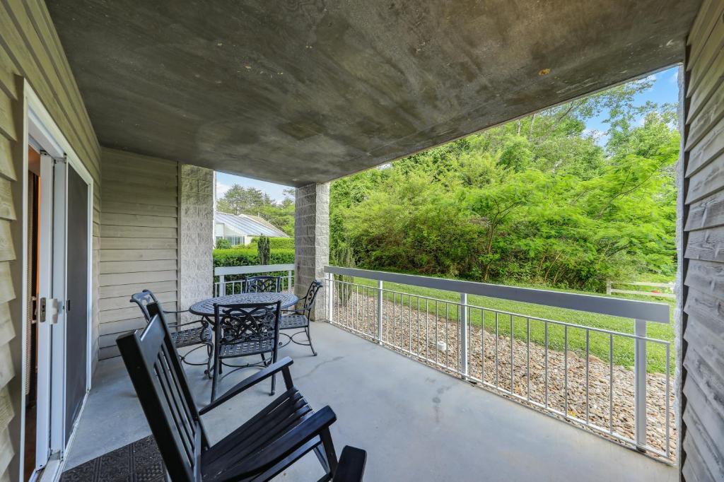 une terrasse couverte avec 2 chaises et une table. dans l'établissement Sweet Dreams Whispering Pines 313, à Pigeon Forge
