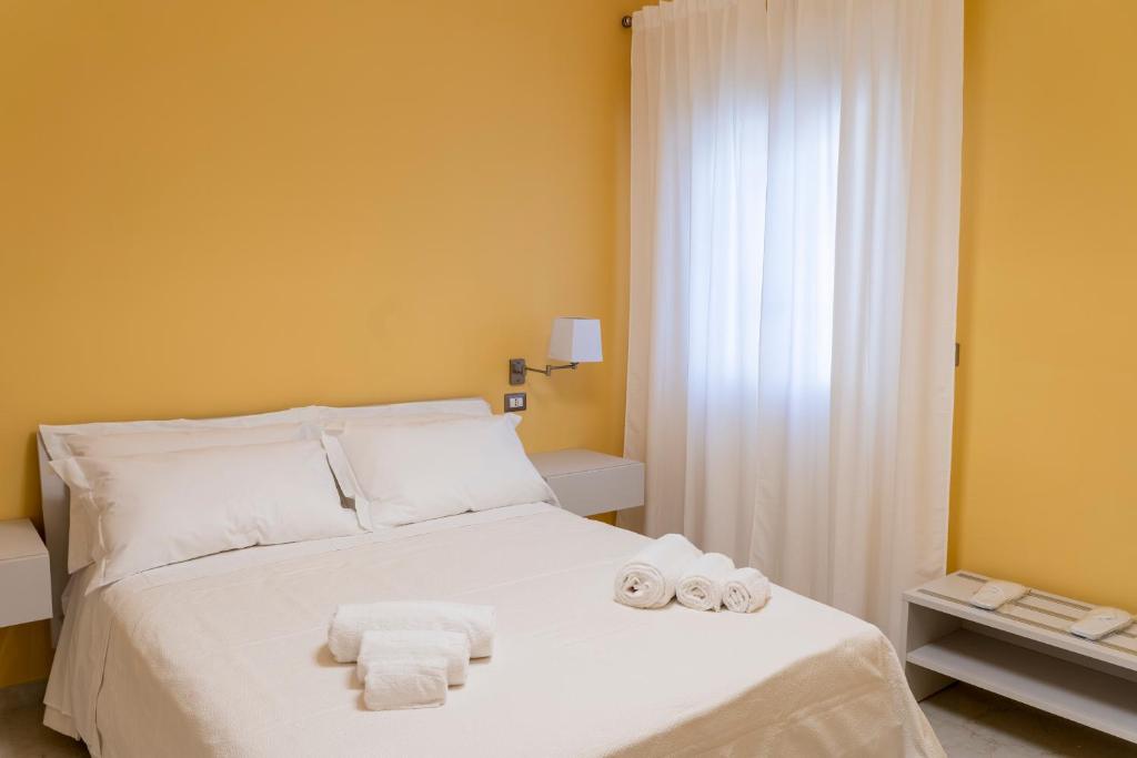 ein Schlafzimmer mit einem weißen Bett und Handtüchern darauf in der Unterkunft A casa dei miei in San Pietro Vernotico
