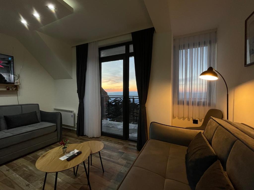 Gencian resort في كوباونيك: غرفة معيشة مع أريكة وطاولة