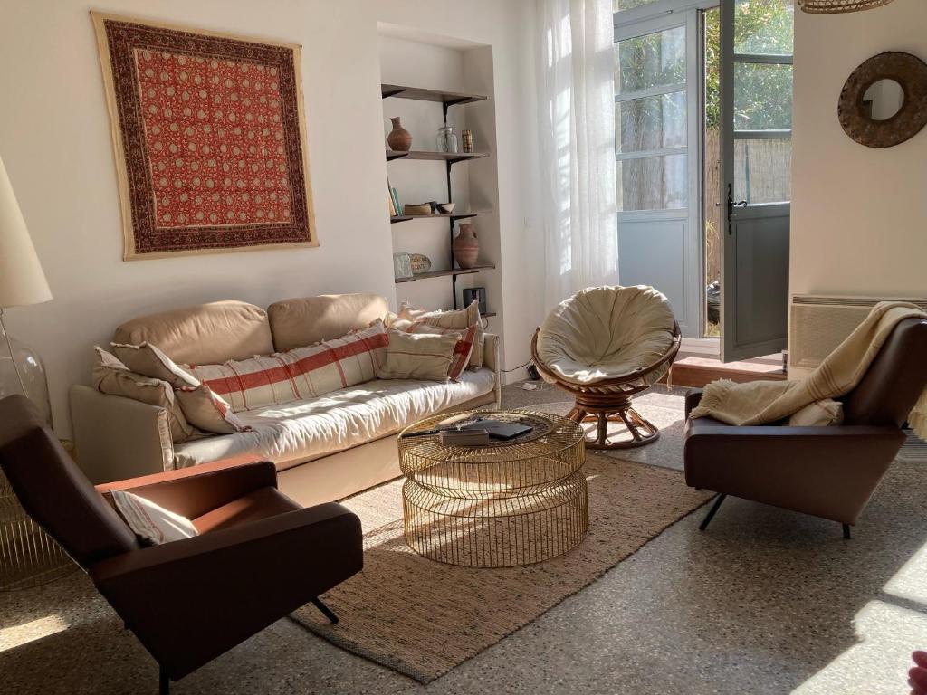 een woonkamer met een bank en 2 stoelen bij L'Oasis de La Roquette in Arles