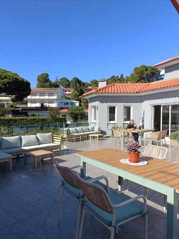 um pátio com mesas e cadeiras e uma mesa e cadeiras em Luna House em Cascais