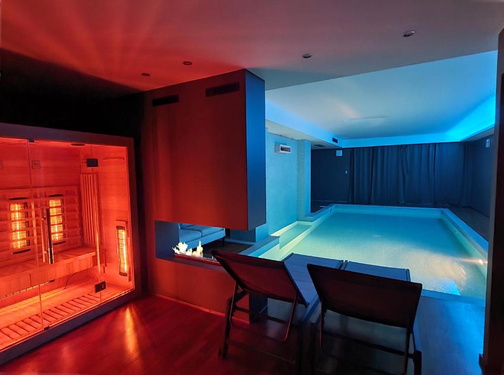 una piscina en una habitación con mesa y sillas en Alysa - Suite Wellness & Spa, en Giarre